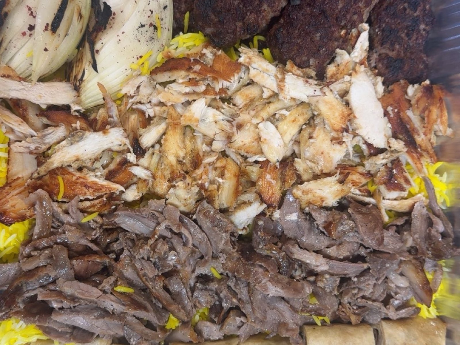 Mixed grill tray with kebab, chicken and beef shawarma over rice